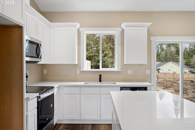 144 E H St, Vernonia, OR 97064 - kitchen featuring stainless steel microwave, a sink, electric range oven, light countertops, and white cabinets