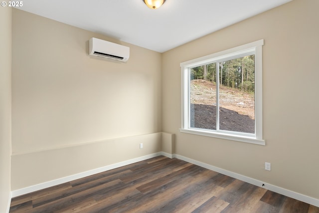 144 E H St, Vernonia, OR 97064 - empty room featuring a wall unit AC, baseboards, and dark wood finished floors