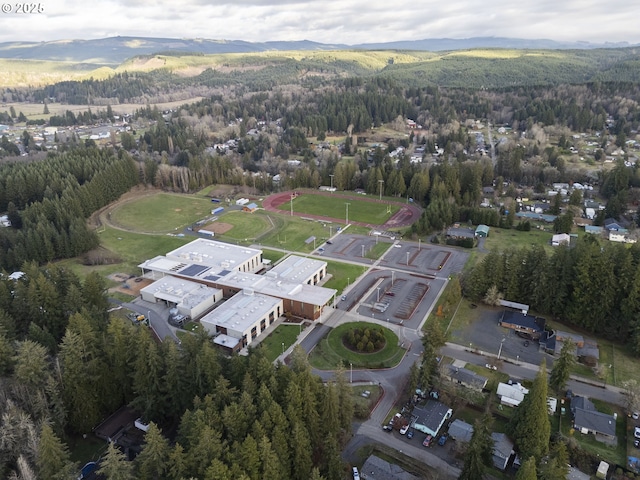 144 E H St, Vernonia, OR 97064 - aerial view of property's location featuring a heavily wooded area and a mountain backdrop