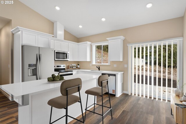 144 E H St, Vernonia, OR 97064 - kitchen featuring appliances with stainless steel finishes, a kitchen island, vaulted ceiling, white cabinets, and light countertops