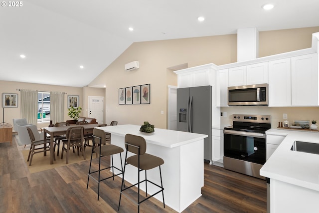 144 E H St, Vernonia, OR 97064 - kitchen featuring stainless steel appliances, a center island, a kitchen bar, light countertops, and white cabinets