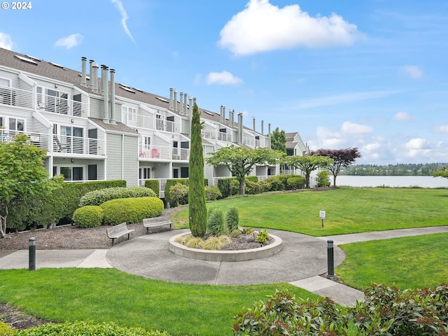 surrounding community featuring a water view and a lawn