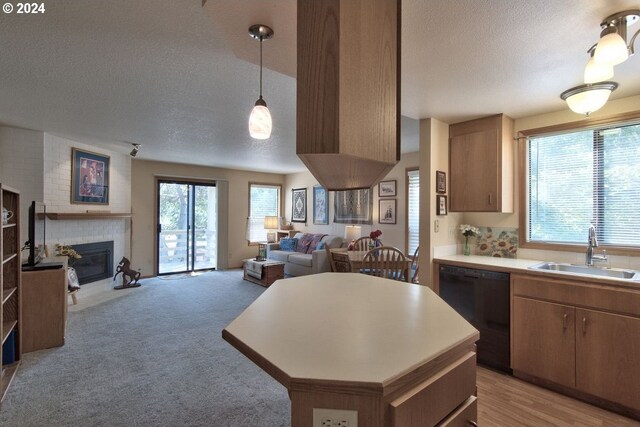 kitchen featuring pendant lighting, plenty of natural light, black dishwasher, and sink