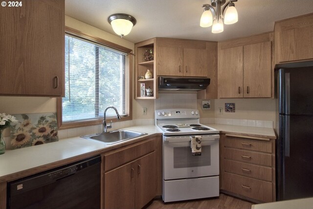 kitchen featuring sink, backsplash, black appliances, and light hardwood / wood-style floors