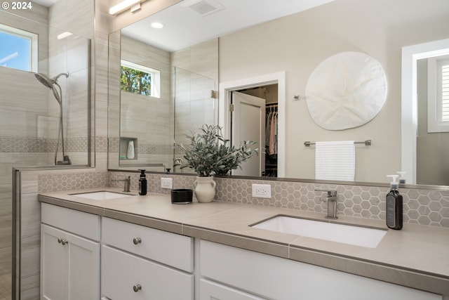 bathroom featuring vanity, a healthy amount of sunlight, and a shower with door