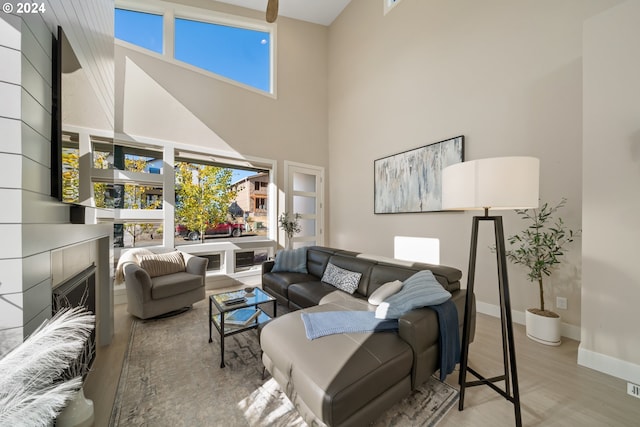 living room with a towering ceiling and light hardwood / wood-style flooring