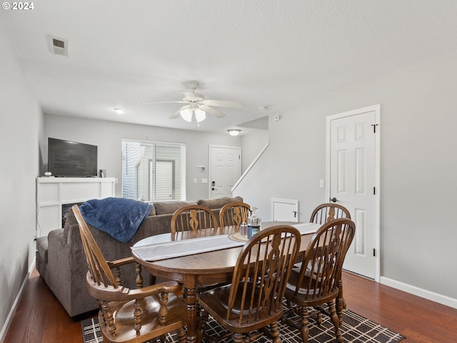 dining area with a textured ceiling, ceiling fan, and dark hardwood / wood-style flooring