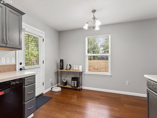 kitchen featuring dark wood-type flooring, plenty of natural light, dishwasher, and a chandelier