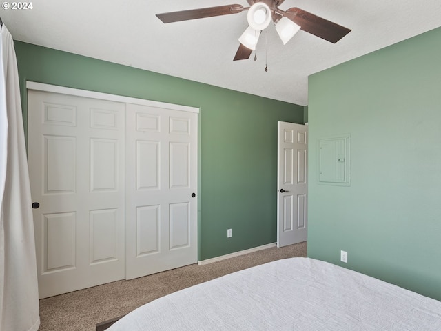 carpeted bedroom with ceiling fan, electric panel, and a closet