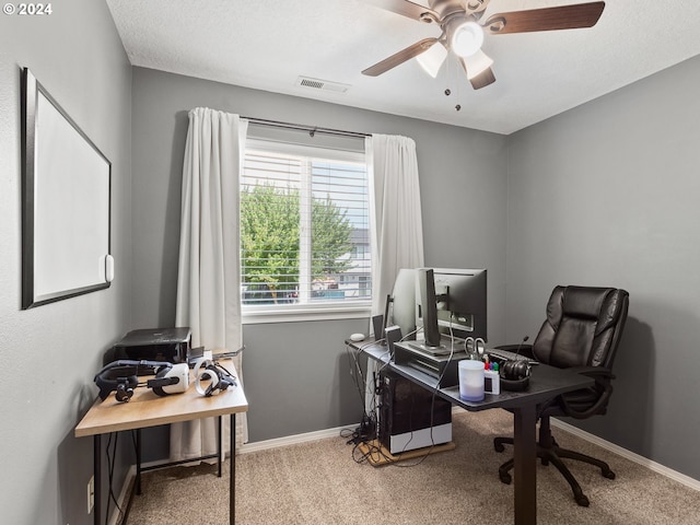 carpeted home office with ceiling fan and a textured ceiling