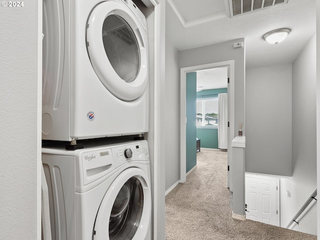 laundry area with a textured ceiling, stacked washer and clothes dryer, and light carpet