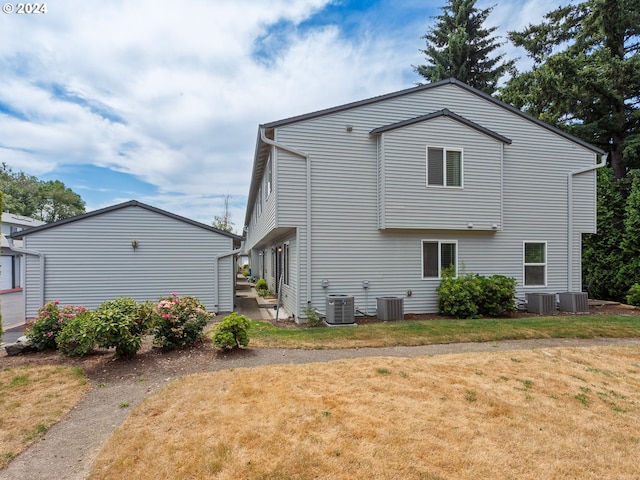 rear view of house with a lawn and central AC unit