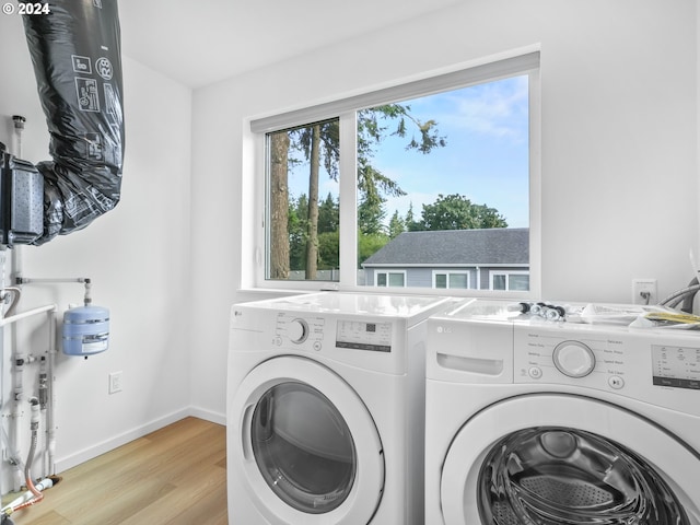 washroom featuring washer and clothes dryer and light hardwood / wood-style flooring