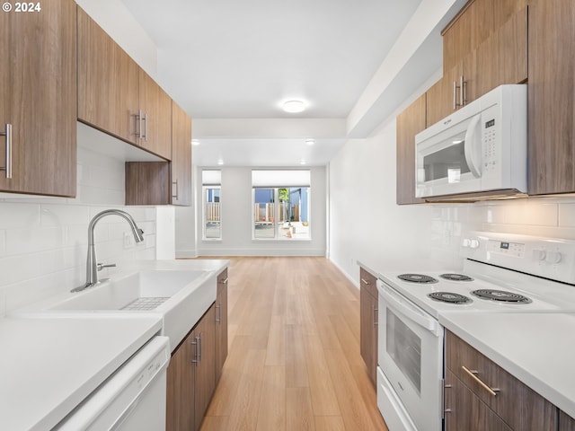 kitchen featuring light hardwood / wood-style flooring, tasteful backsplash, sink, and white appliances