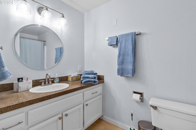 bathroom with vanity, wood-type flooring, and toilet