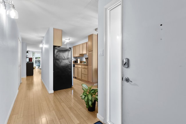 kitchen with black fridge and light wood-type flooring