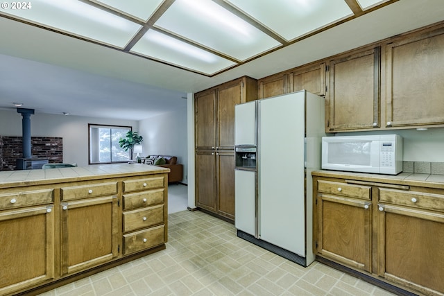 kitchen with a wood stove, tile counters, and white appliances