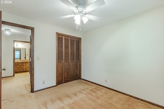 unfurnished bedroom with light carpet, ceiling fan, and a closet