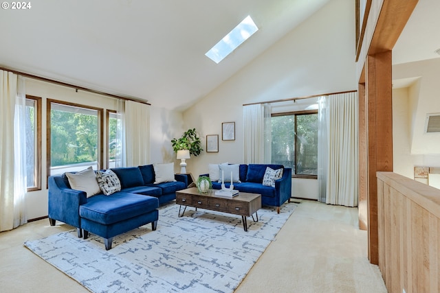 living room featuring high vaulted ceiling, a skylight, and light colored carpet