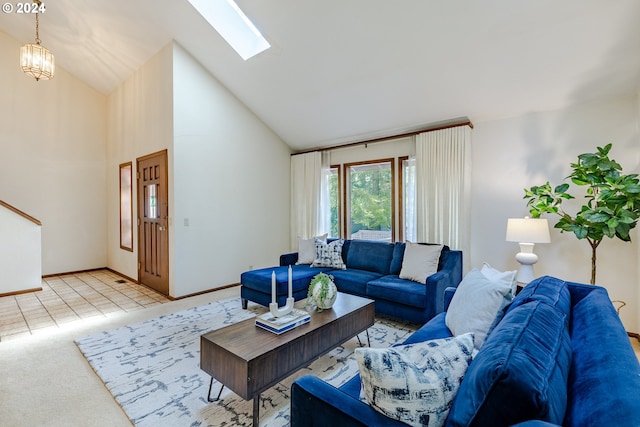 carpeted living room with high vaulted ceiling, an inviting chandelier, and a skylight