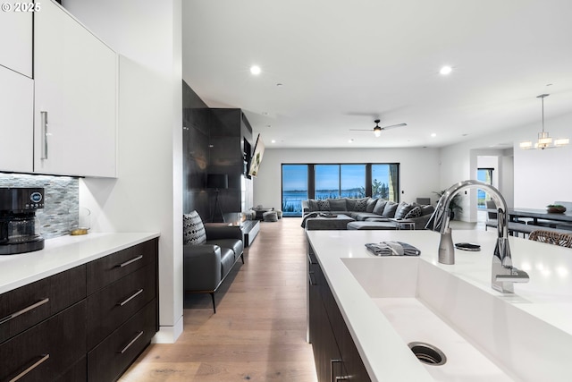 kitchen featuring light countertops, modern cabinets, light wood-type flooring, and a sink