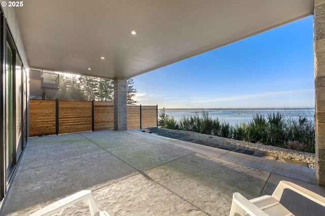 view of patio / terrace with a water view and fence