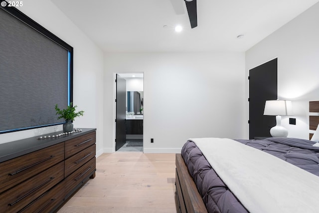 bedroom with ceiling fan, baseboards, light wood-type flooring, and connected bathroom