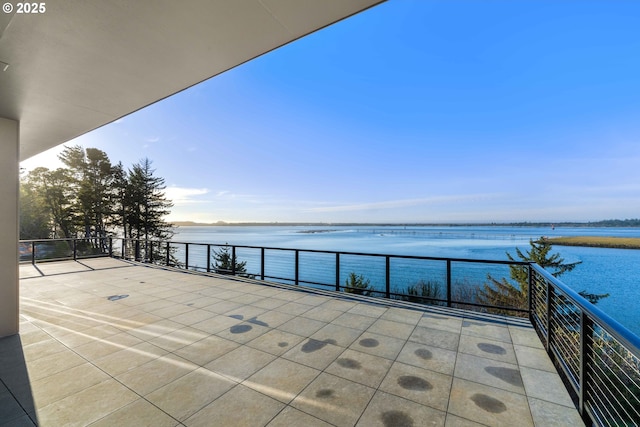 view of patio with a water view and a balcony