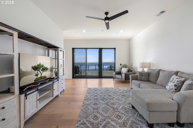 living room featuring light wood-style flooring, recessed lighting, a ceiling fan, and visible vents