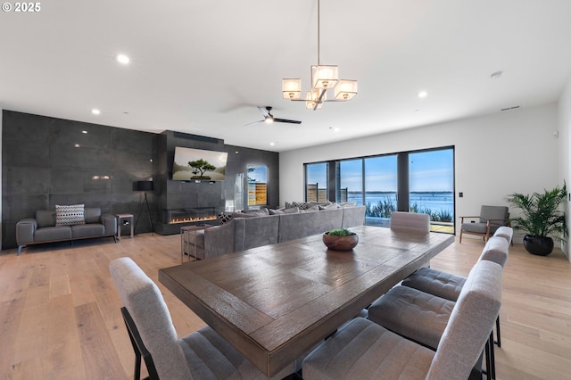 dining area featuring recessed lighting, a glass covered fireplace, light wood-style flooring, and ceiling fan