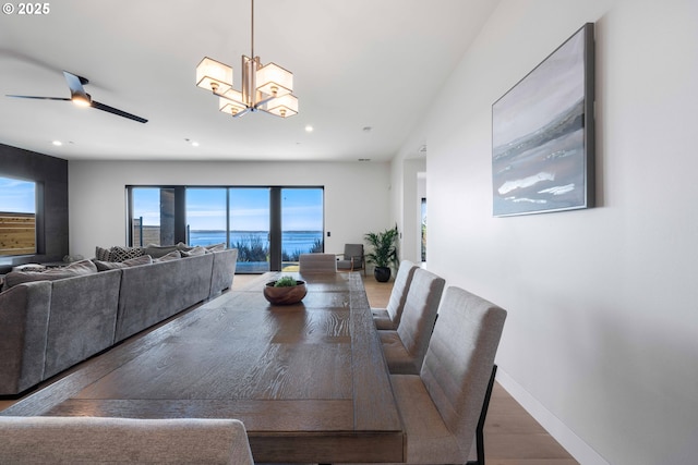 dining room featuring recessed lighting, baseboards, wood finished floors, and ceiling fan with notable chandelier