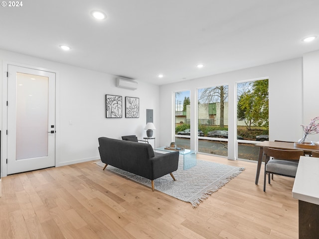 living room with light hardwood / wood-style floors and a wall mounted AC