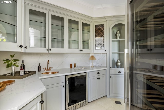 bar featuring backsplash, light tile patterned floors, beverage cooler, ornamental molding, and sink