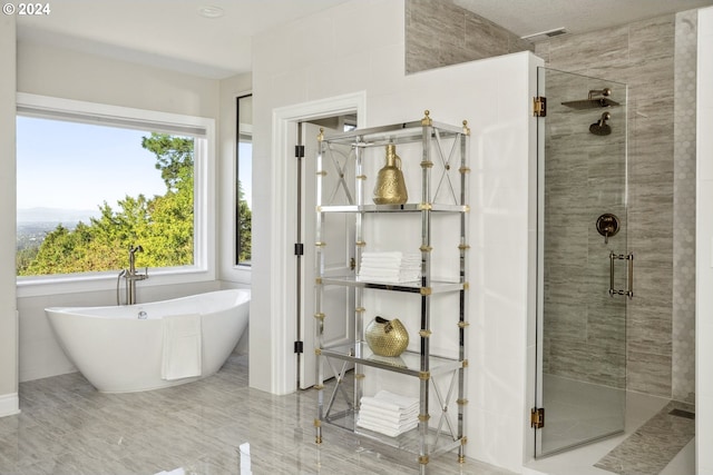 bathroom featuring shower with separate bathtub