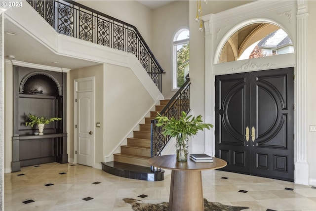 entryway featuring a towering ceiling and light tile patterned floors