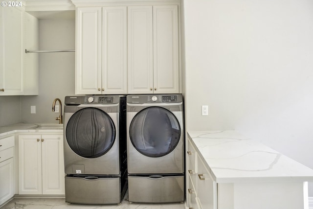 laundry room with cabinets, washer and dryer, and sink