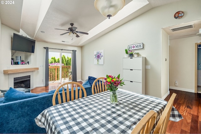 dining area with ceiling fan, dark hardwood / wood-style flooring, and vaulted ceiling