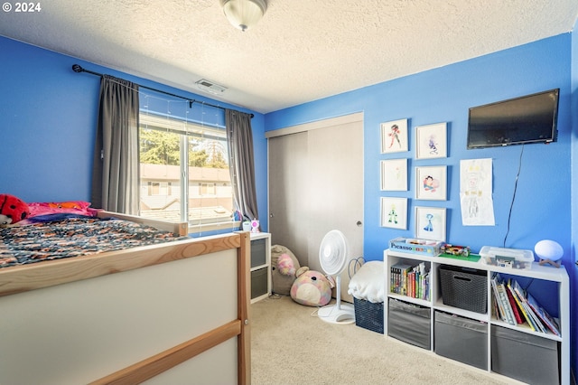 carpeted bedroom featuring a closet and a textured ceiling