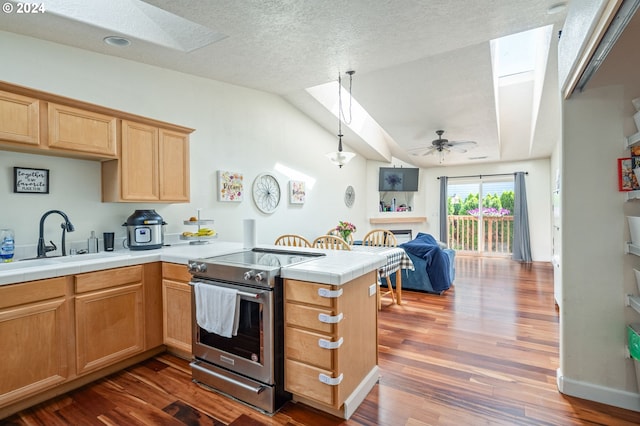 kitchen featuring stainless steel range with electric stovetop, pendant lighting, dark wood-type flooring, ceiling fan, and kitchen peninsula