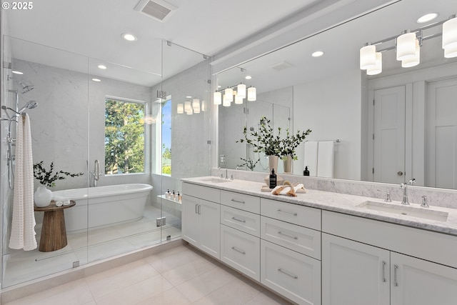 bathroom featuring visible vents, double vanity, a stall shower, a freestanding tub, and a sink