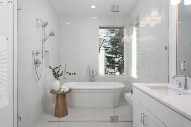 bathroom with tile walls, a stall shower, and vanity