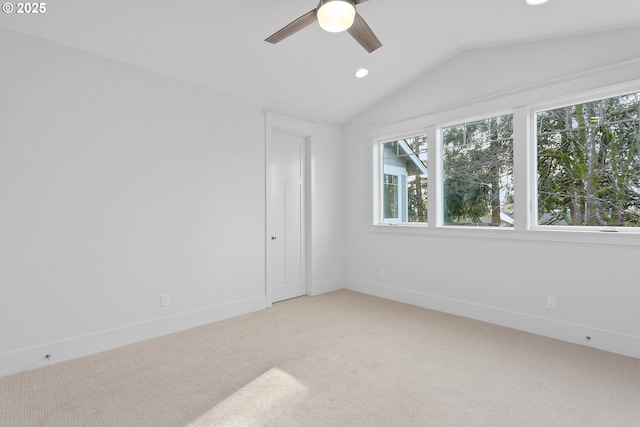 empty room featuring baseboards, lofted ceiling, recessed lighting, ceiling fan, and light carpet