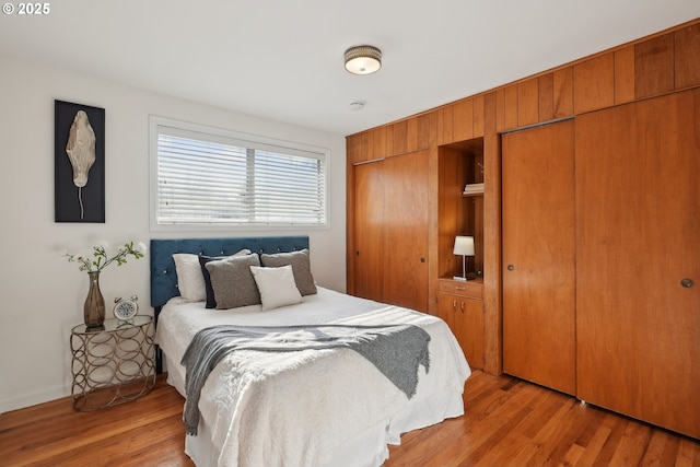 bedroom featuring light hardwood / wood-style flooring and two closets