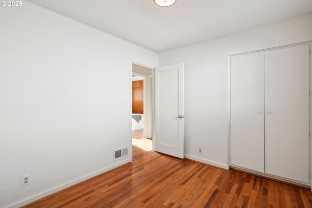 unfurnished bedroom with hardwood / wood-style floors and a closet