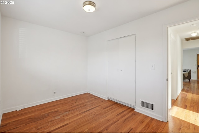 unfurnished bedroom featuring light hardwood / wood-style floors and a closet