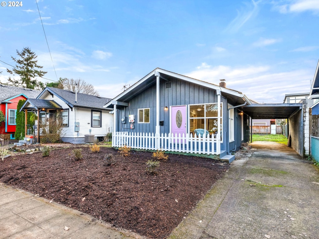 view of front facade with central AC unit and a carport