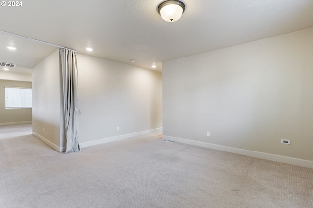 unfurnished room with recessed lighting, visible vents, light carpet, and baseboards