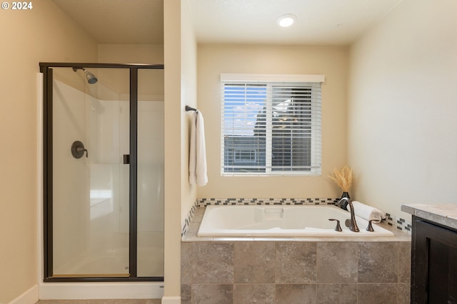 full bath with a shower stall, vanity, and a garden tub