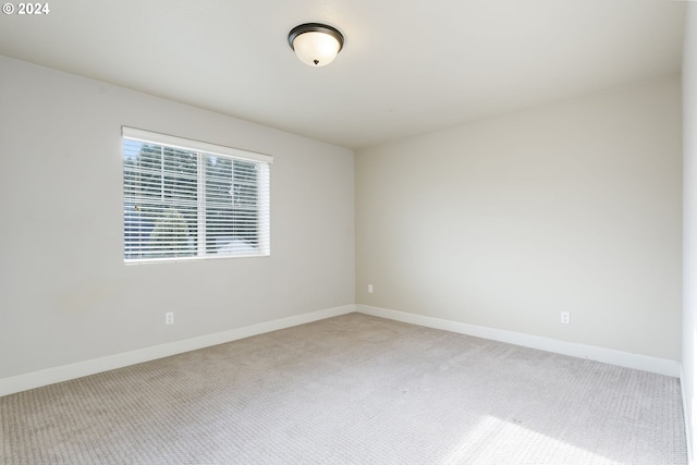 carpeted empty room featuring baseboards