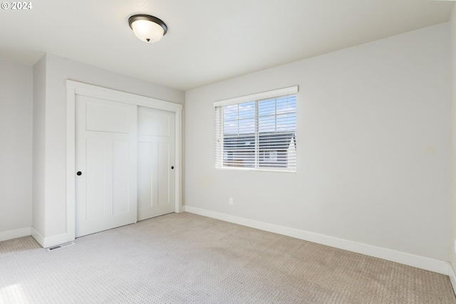 unfurnished bedroom featuring a closet, baseboards, and carpet